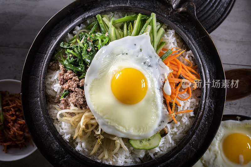 BI Bim Bap，拌菜饭，顶视图与热酱在铸铁锅